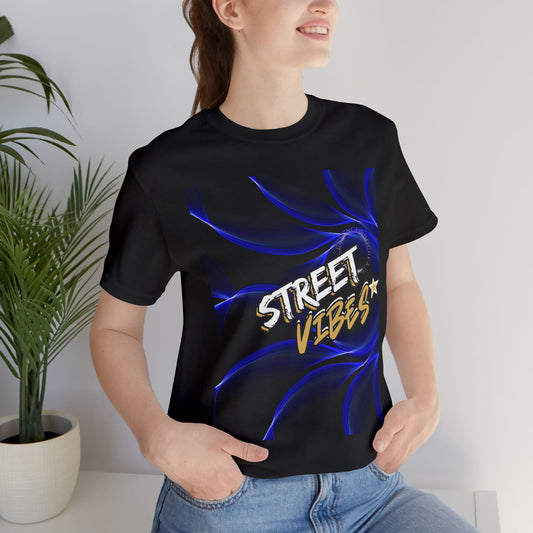 Person wearing a black EssenceInnoCreate t-shirt with 'Street Vibes' design, standing indoors next to a plant.