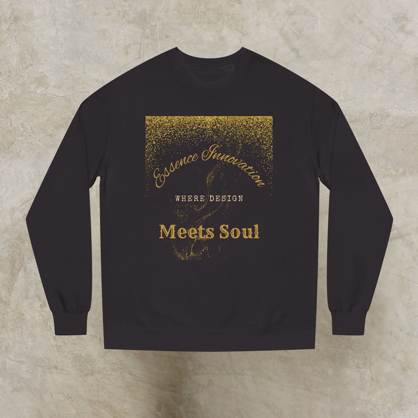Black sweatshirt with gold Essence Innovation 'Design Meets Soul' text on a textured beige background