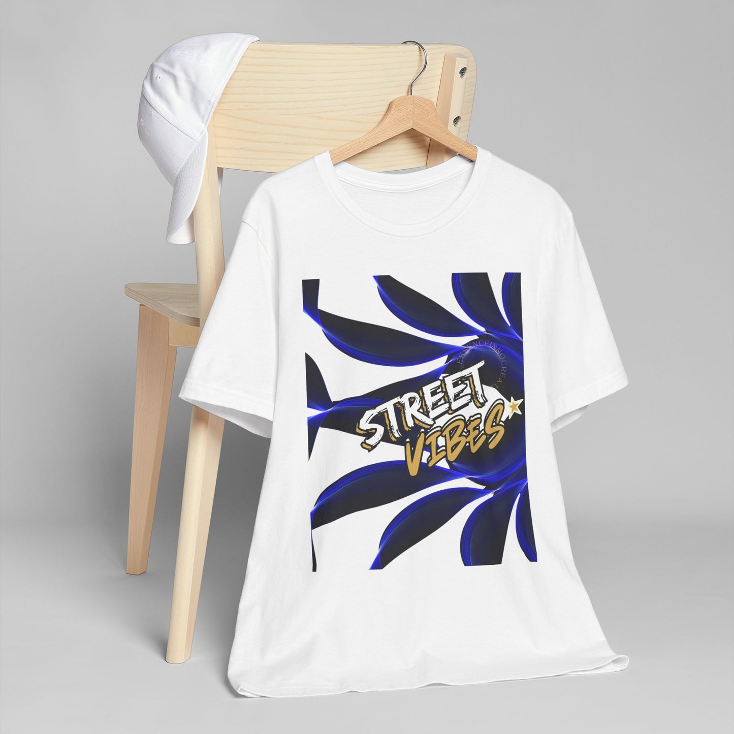 White EssenceInnoCreate t-shirt with 'Street Vibes' graphic design on a wooden chair against a gray background