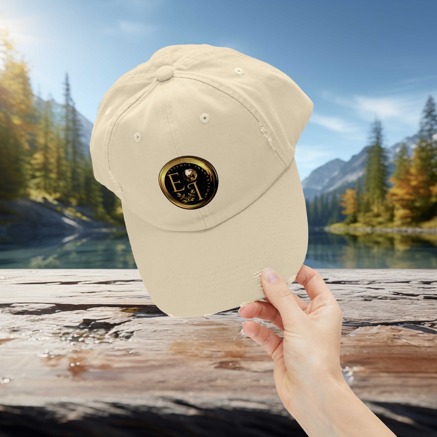 Beige Essence Innovation cap with a logo held by a hand against a scenic background of trees and water.