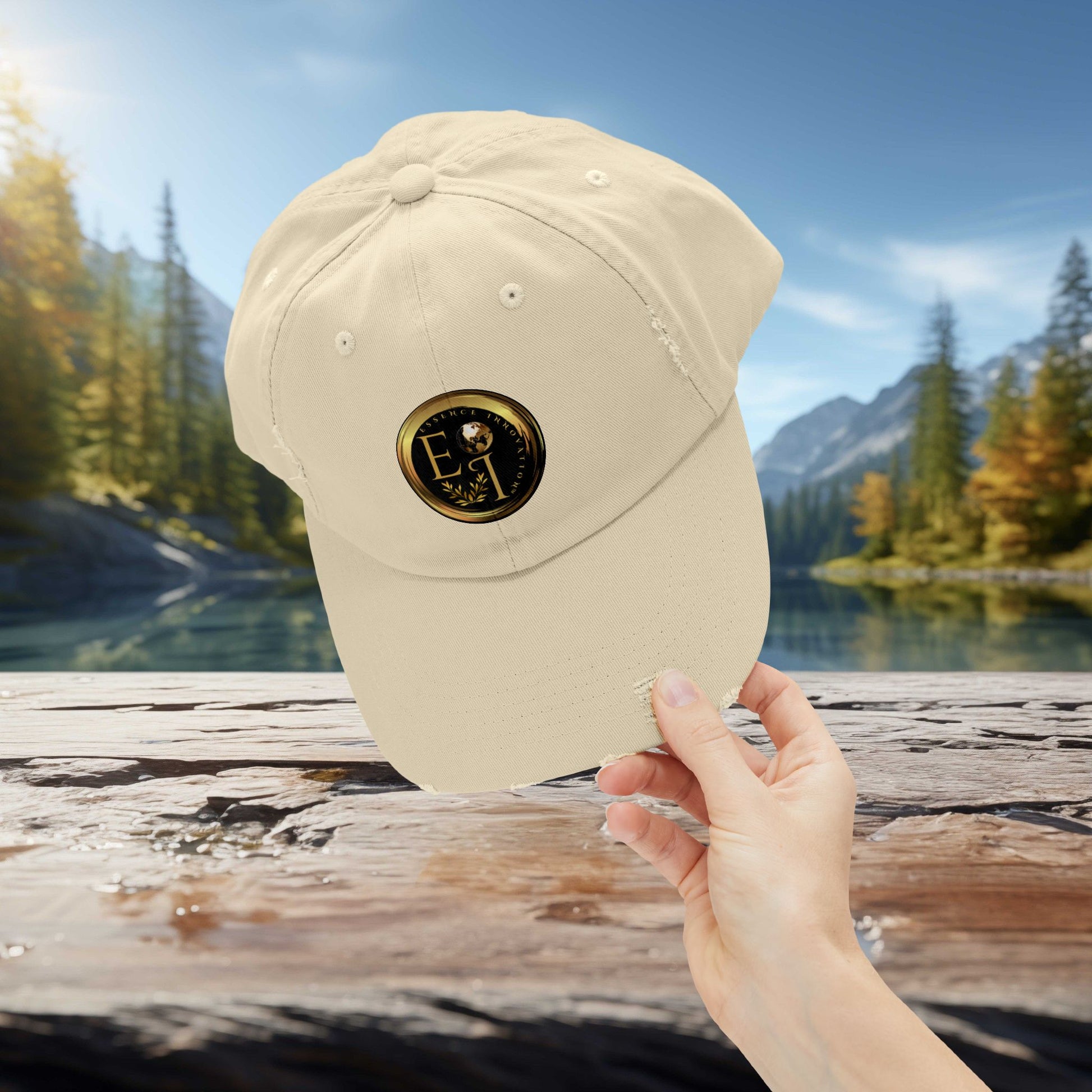 Beige Essence Innovation cap with a logo held by a hand against a scenic background of trees and water.