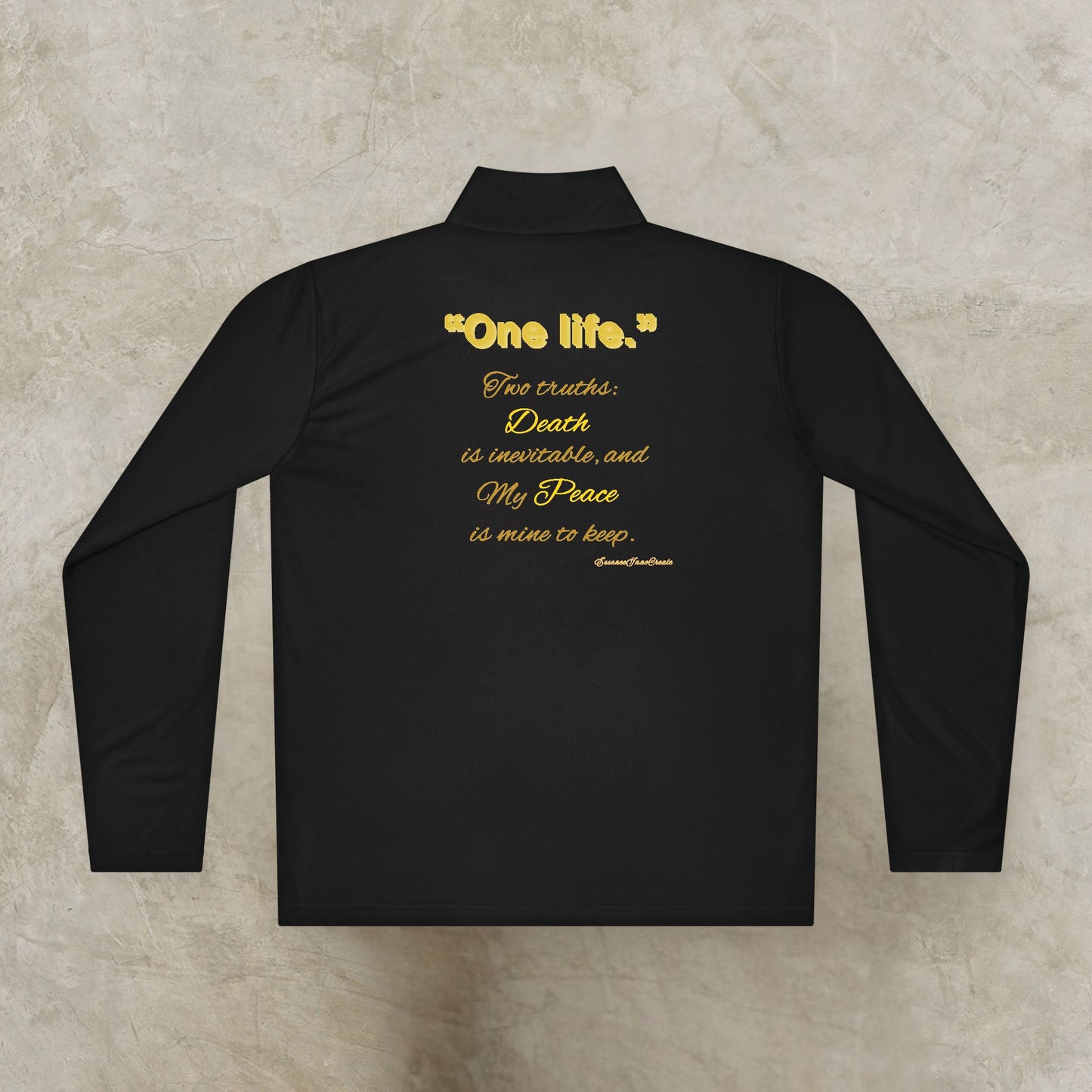 Black long-sleeve shirt with yellow One Life text on a textured beige background