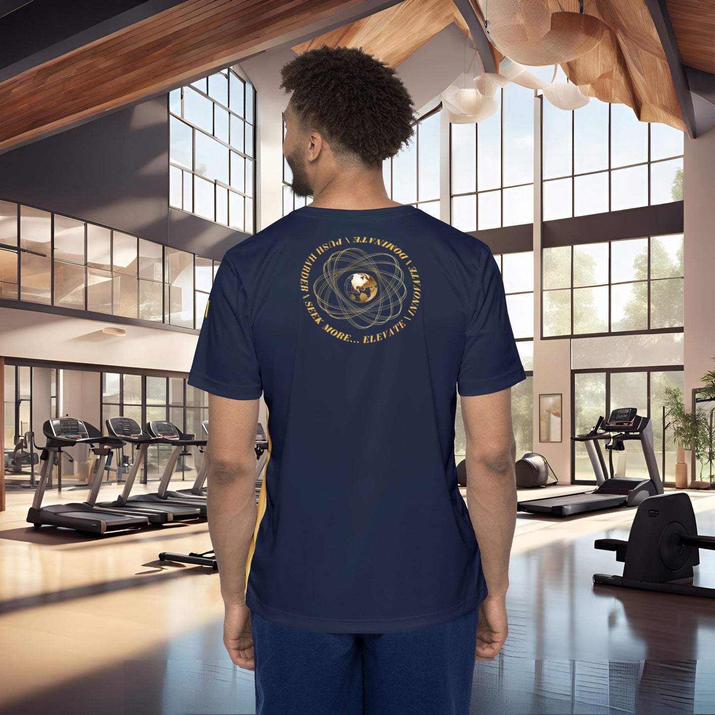 Man wearing a navy blue t-shirt with a Essence Innovation Seek More
 design on the back in a gym setting