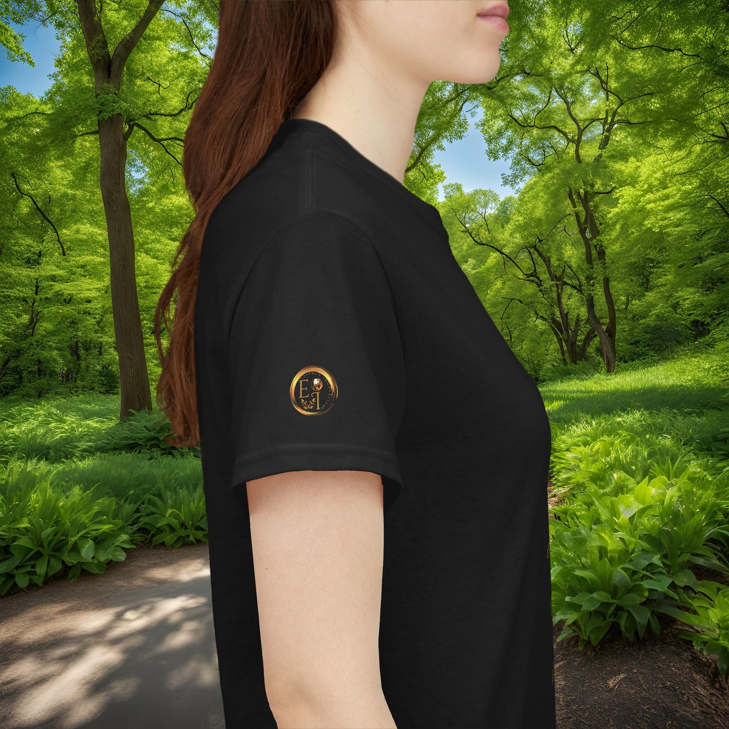 Person wearing a black t-shirt with a Essence Innovation logo in a forest setting