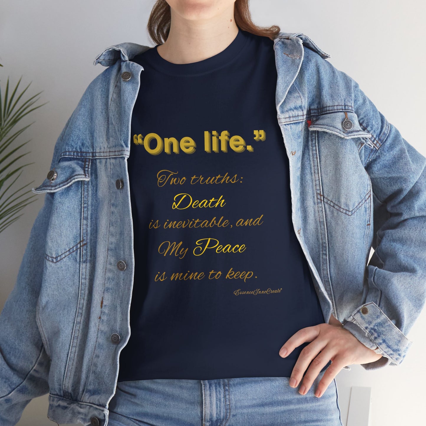 Person wearing a navy blue t-shirt with yellow One Life text and a denim jacket.
