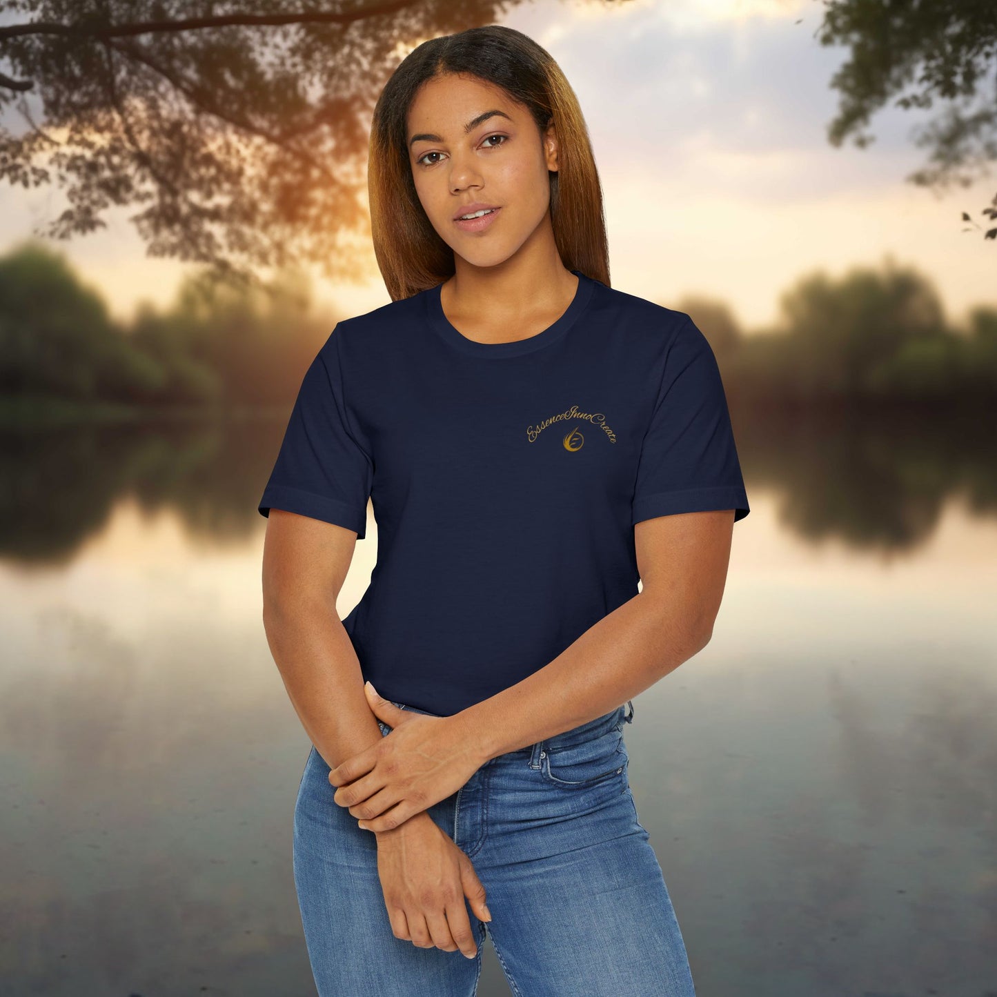 Woman wearing a navy blue t-shirt with 'EssenceInnoCreate' logo, standing outdoors by a body of water.