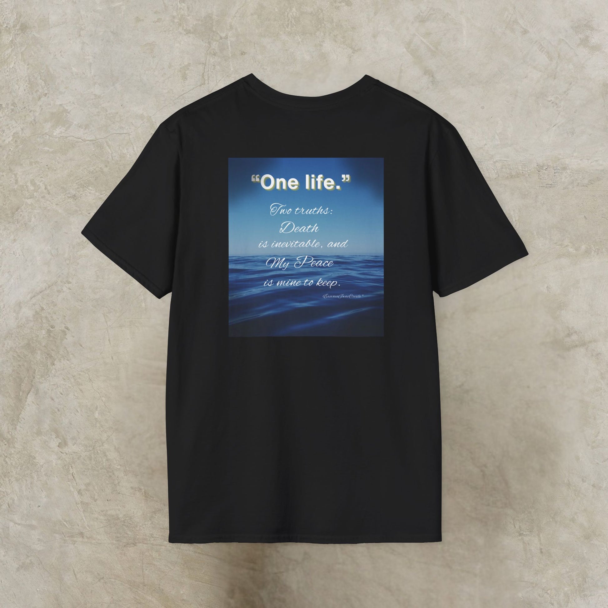 Black t-shirt with a blue graphic and One Life text on a textured beige background