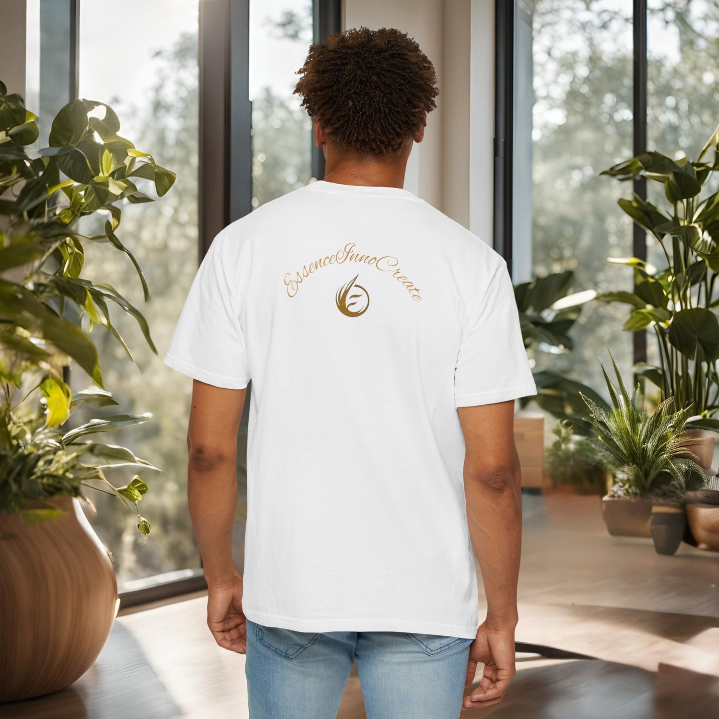 Person wearing a white t-shirt with an 'EssenceInnoCreate' logo in a room with large windows and plants.