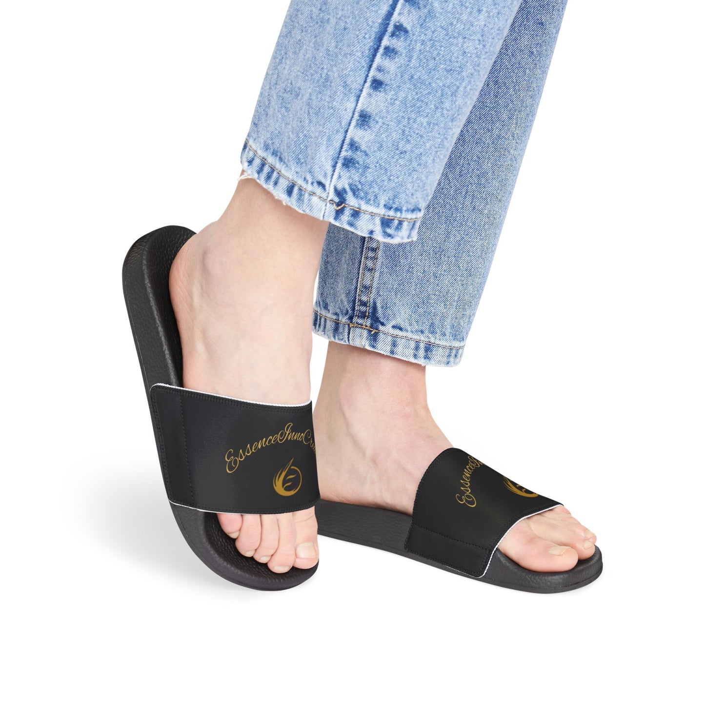 Black EssenceInnoCreate slides worn with blue jeans on a white background