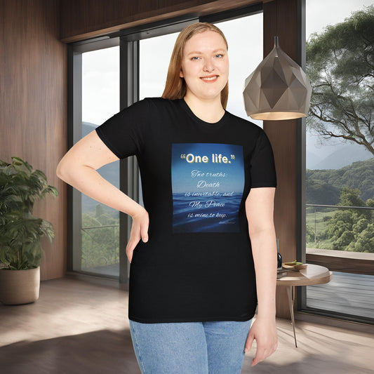 Person wearing a black 'One Life' t-shirt with a blue design and text in a room with large windows.