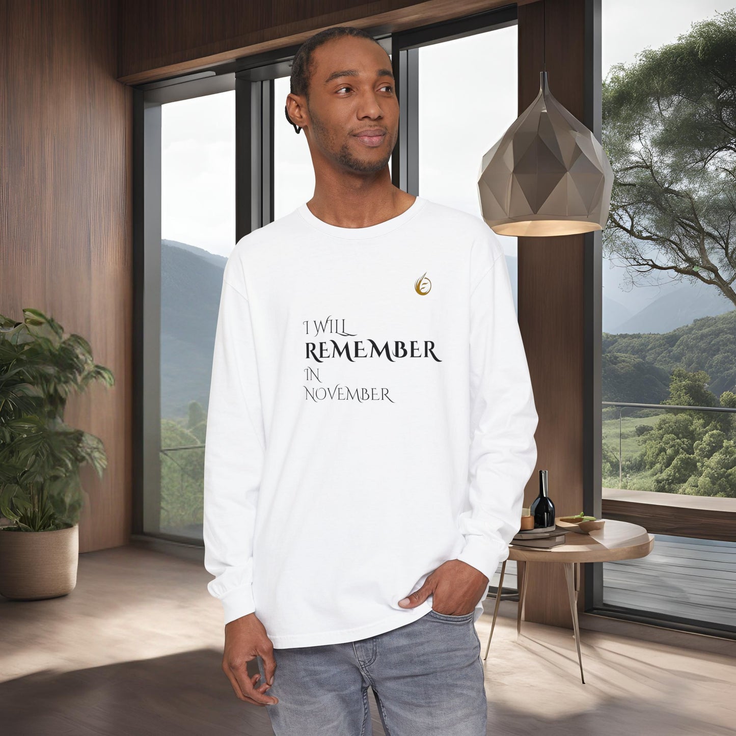 Man wearing a white long-sleeve EssenceInnoCreate Quiet Resolve shirt with text in a modern room with large windows.