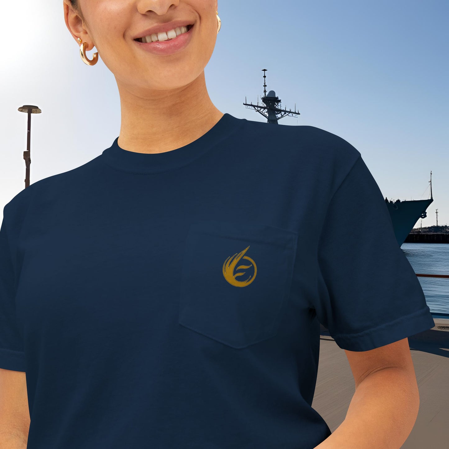 Person wearing a navy blue t-shirt with a yellow 'EssenceInnoCreate' logo, standing in front of a large ship.