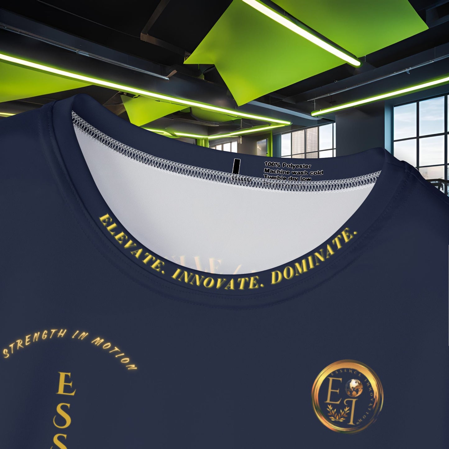 Navy blue t-shirt with gold Essence Innovation logo and text and logo in a modern indoor setting