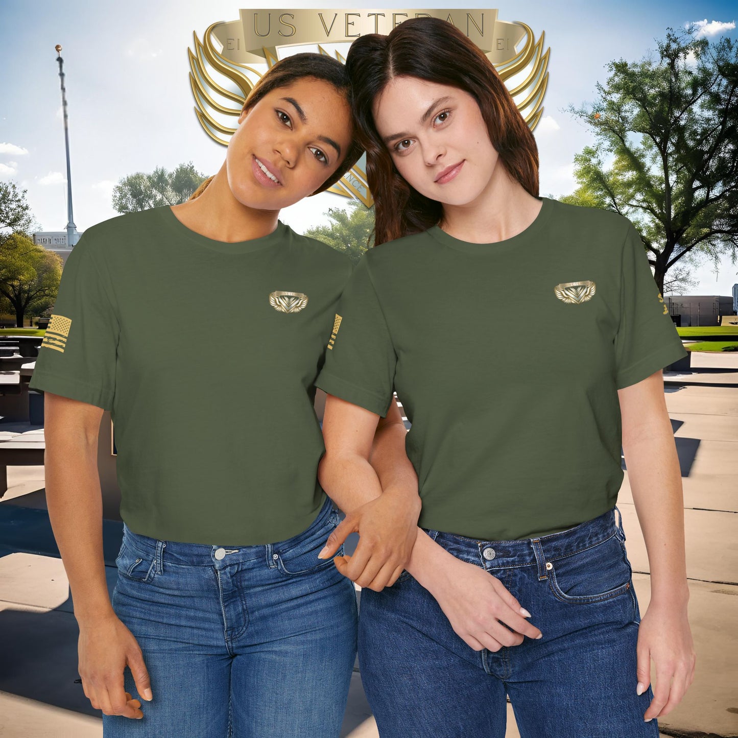 Two women wearing green t-shirts with a logo, standing in front of a U.S. Veterans monument.