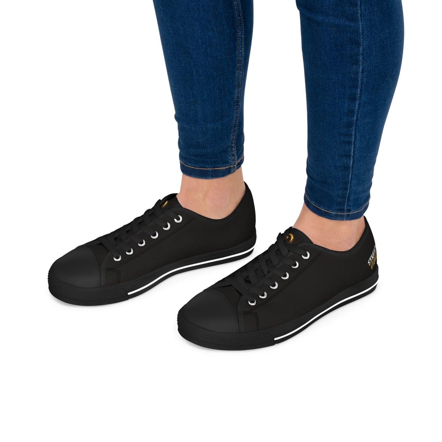Black sneakers with Essence Innovation 'Street Vibes' branding worn with blue jeans on a white background