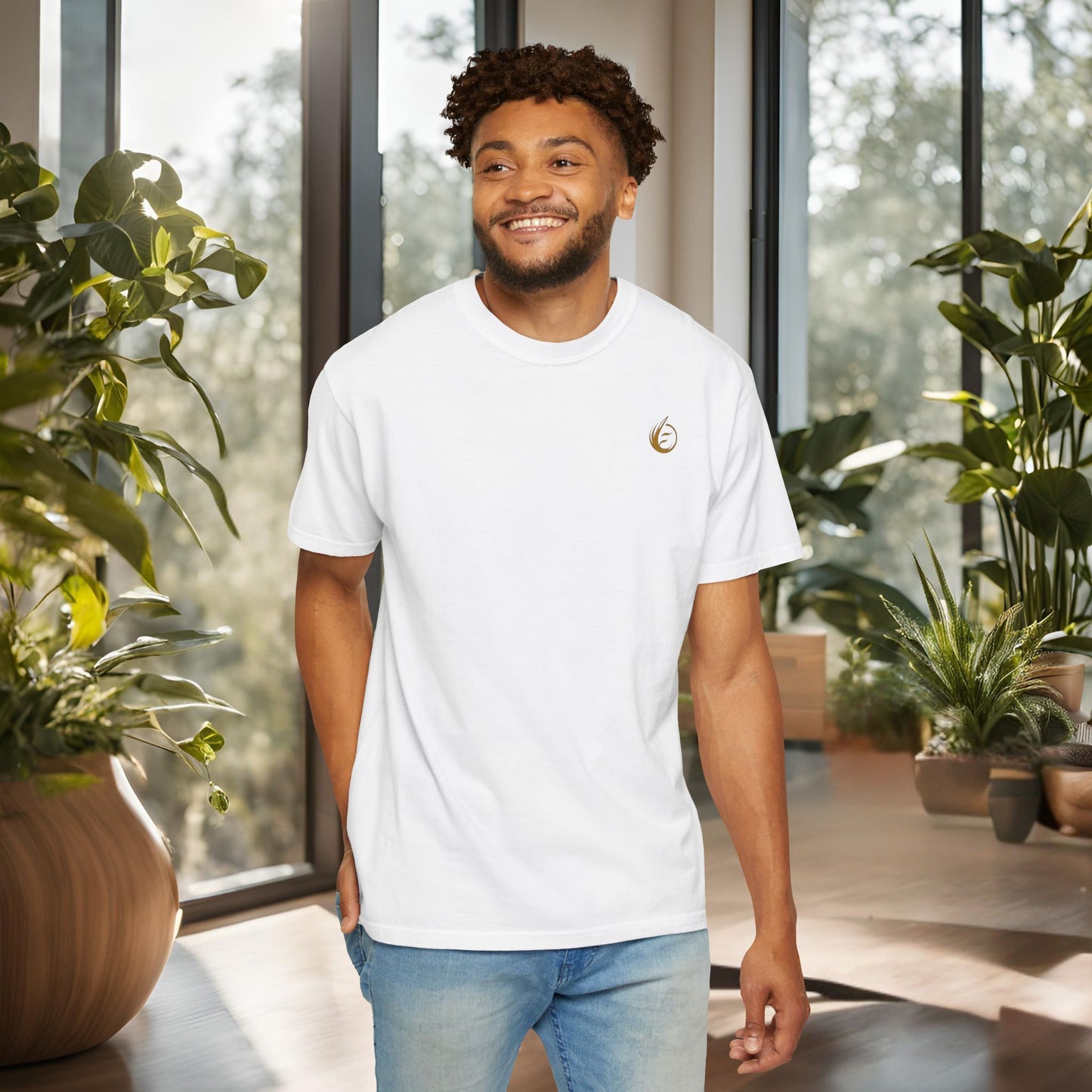 Man wearing a white t-shirt with 'EssenceInnoCreate' logo in a modern indoor setting with plants