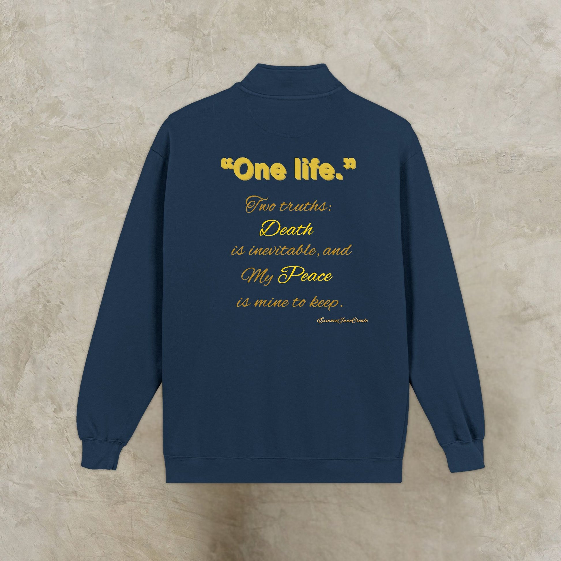 Navy blue sweatshirt with yellow One Life text on a beige background