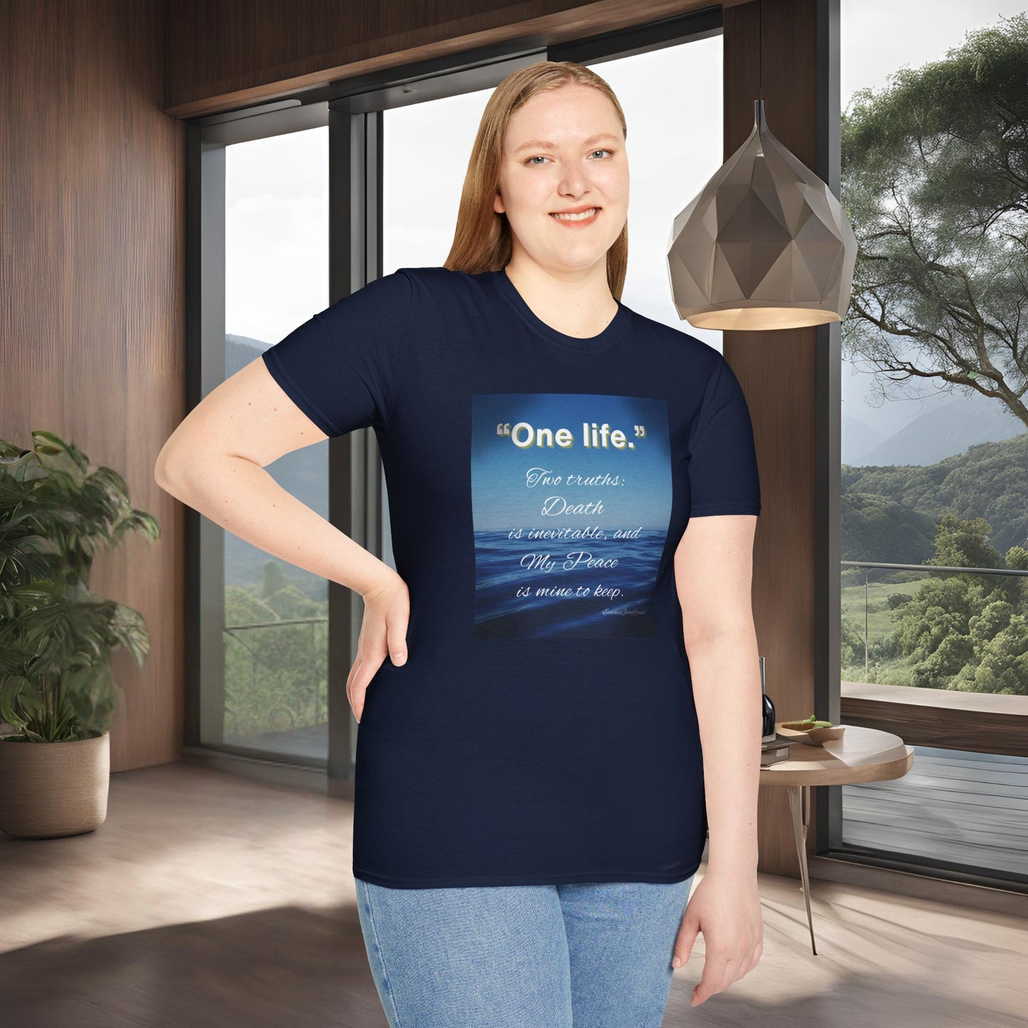 Person wearing a navy blue 'One Life' t-shirt with a motivational quote in a modern room with large windows.