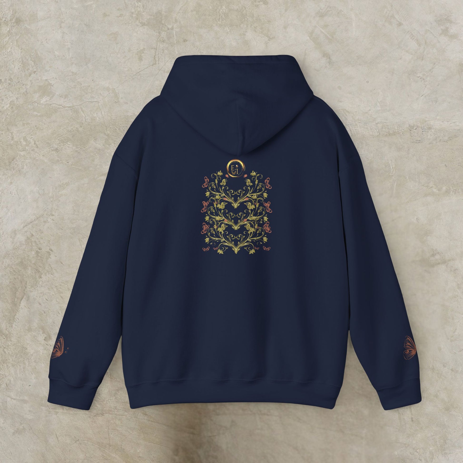Navy blue hoodie with floral Essence Innovation Bohemian Butterfly Crest design on the back against a beige background