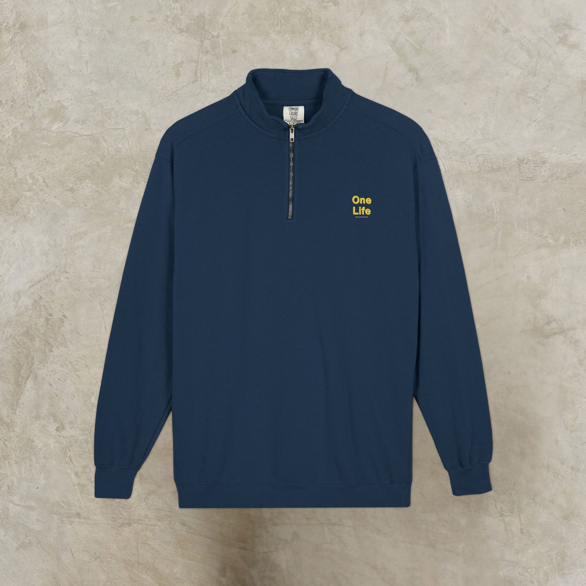 Navy blue sweatshirt with 'One Life' logo on a beige background