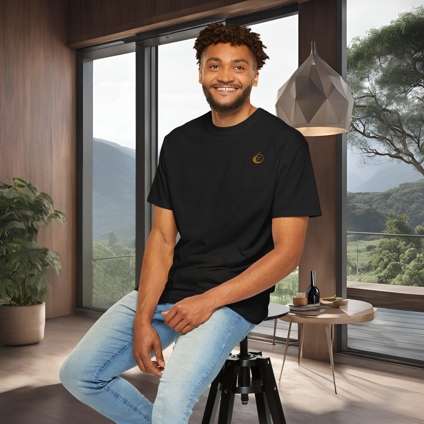 Man sitting on a stool in a modern room with large windows and a scenic view.