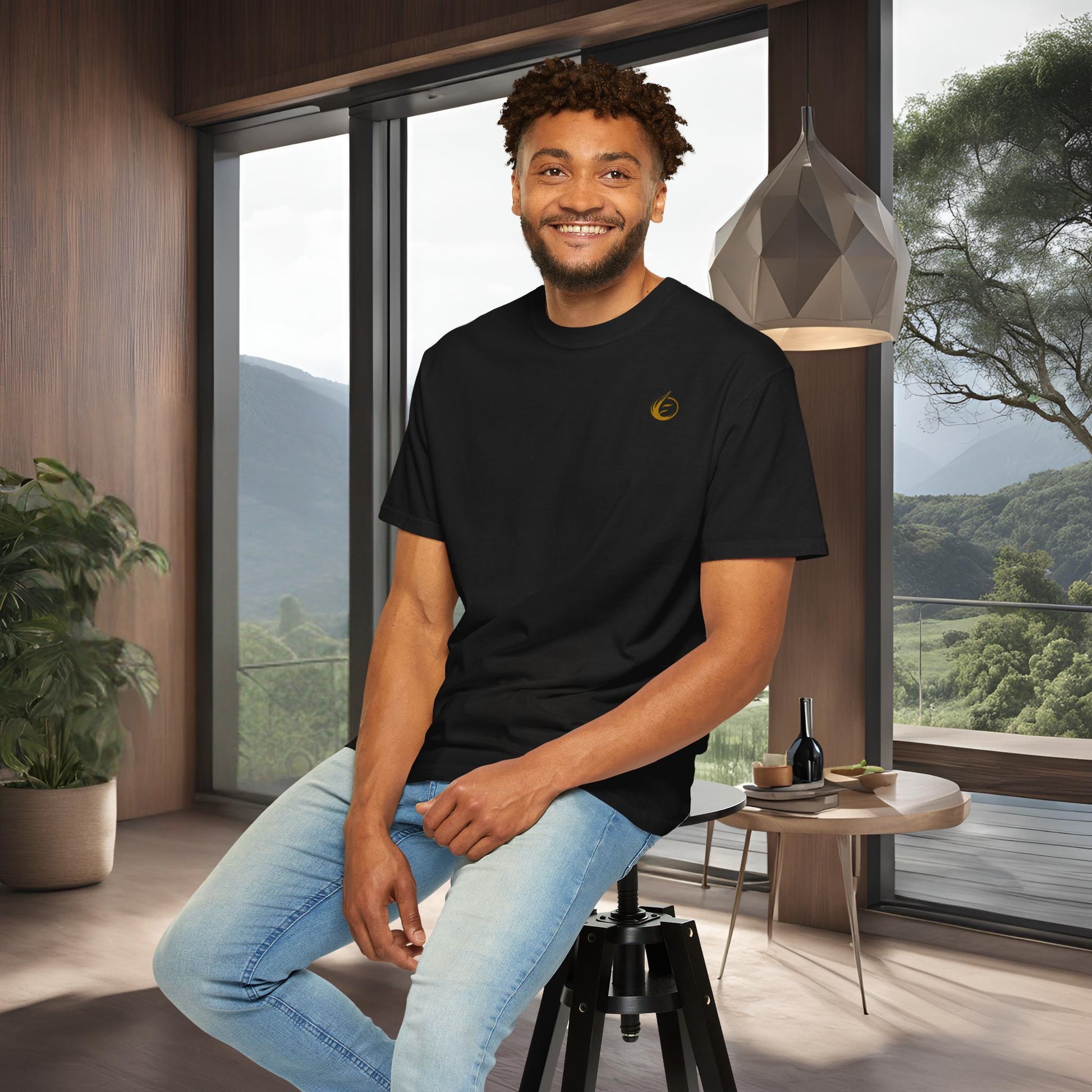 Man sitting on a stool in a modern room with large windows and a scenic view.