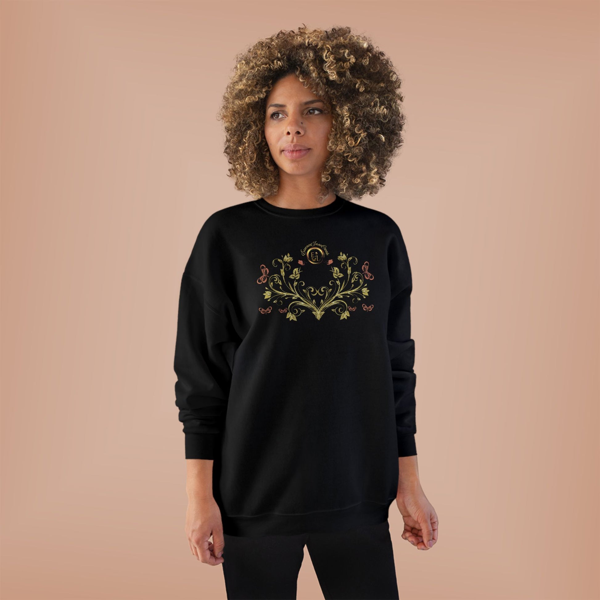 Person wearing a black sweatshirt with Essence Innovation Bohemian Butterfly Crest text on a beige background