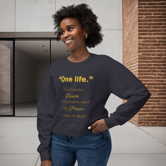 Woman wearing a dark blue sweatshirt with yellow One Life text in an indoor setting.
