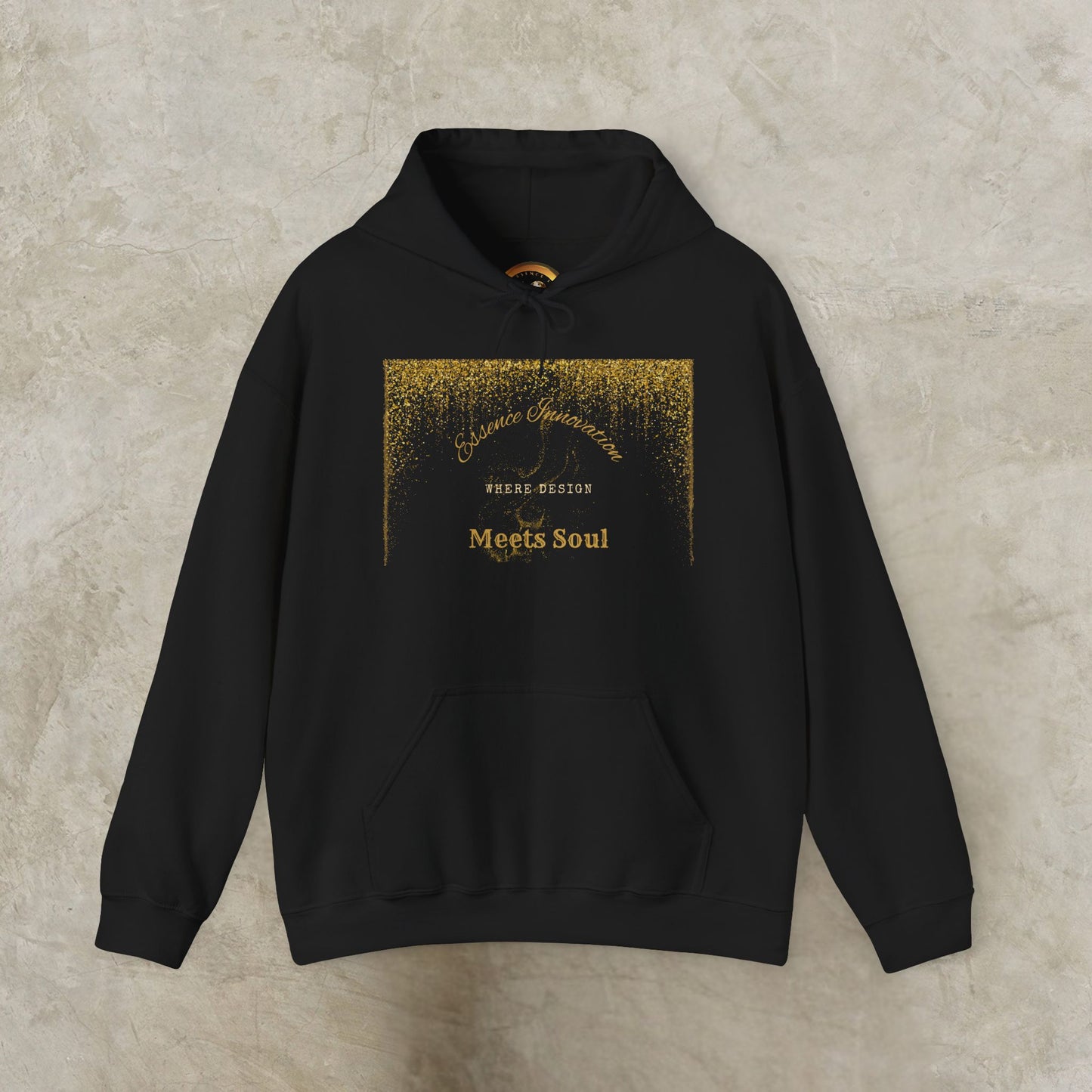 Black hoodie with gold Essence Innovation 'Design Meets Soul' text on a textured beige background