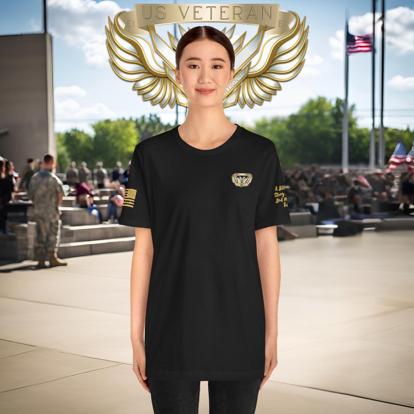 Person wearing a black t-shirt with gold emblem and 'US Veteran' text, standing in front of a crowd.