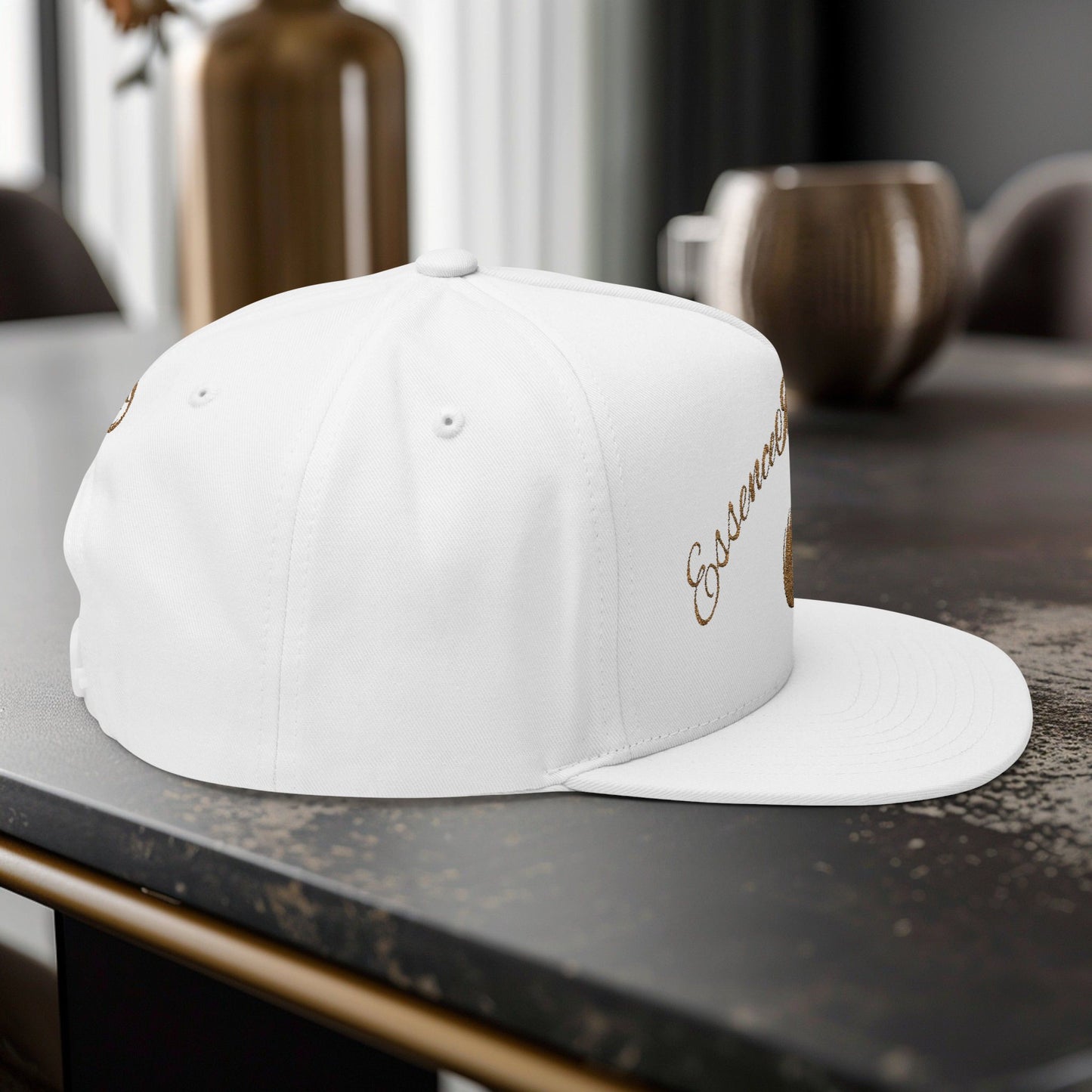 White cap with gold EssenceInnoCreate text on a dark surface