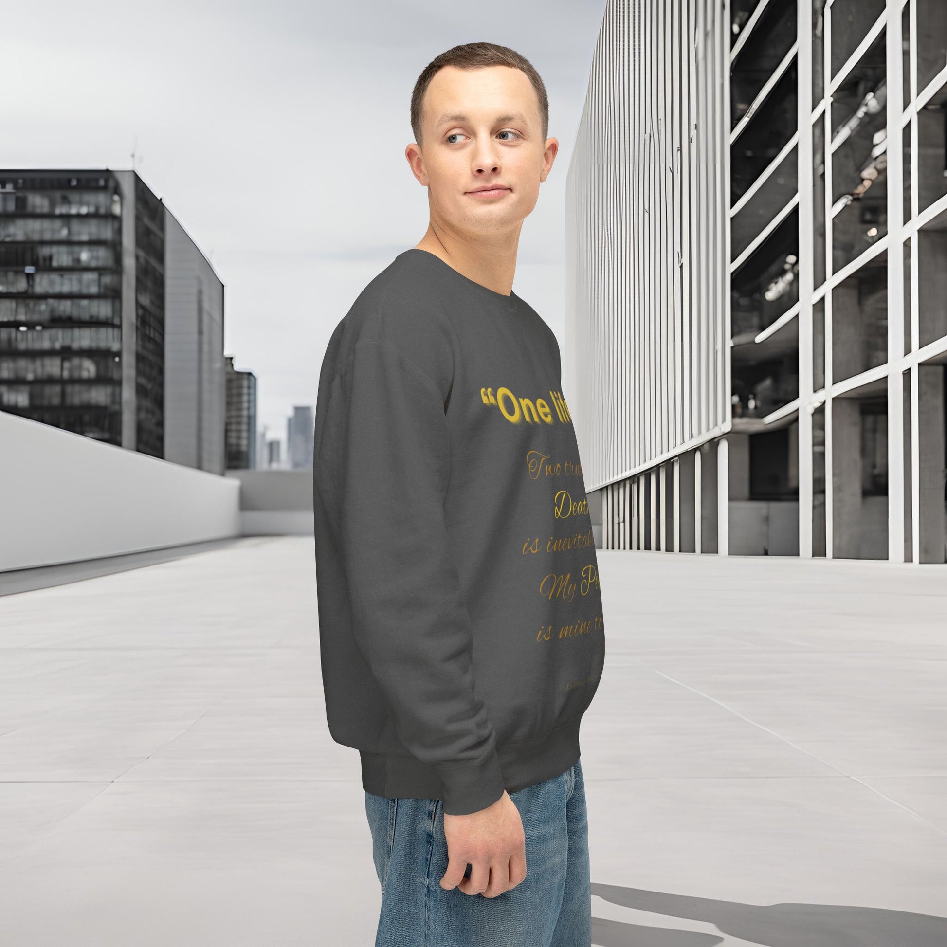 Man wearing a dark gray sweatshirt with yellow text in an urban setting