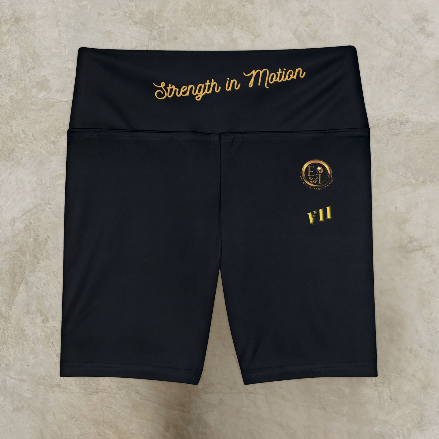Black shorts with gold text and logo on a beige background