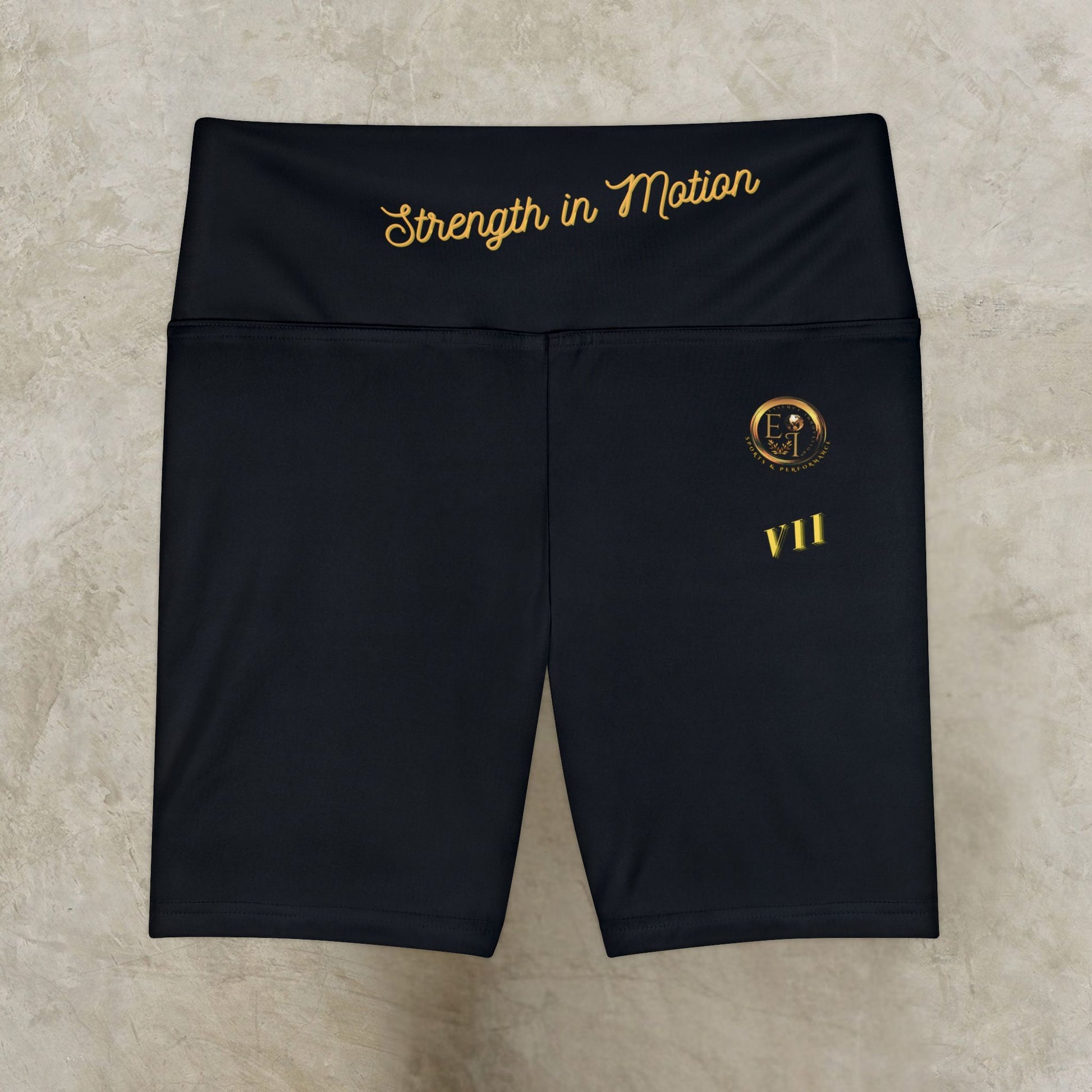 Black shorts with gold text and logo on a beige background