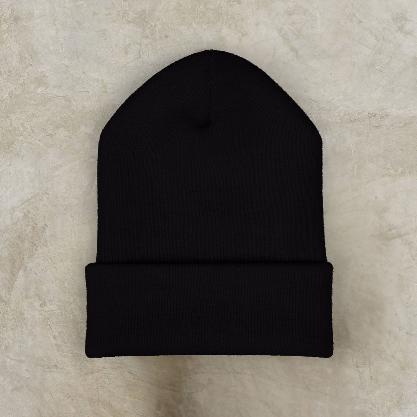 Black beanie on a beige textured background