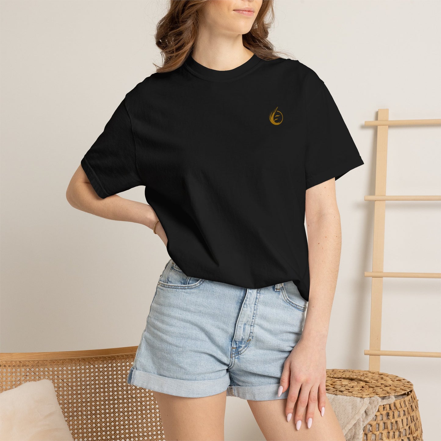 Person wearing a black t-shirt with 'EssenceInnoCreate' printed on it and denim shorts.