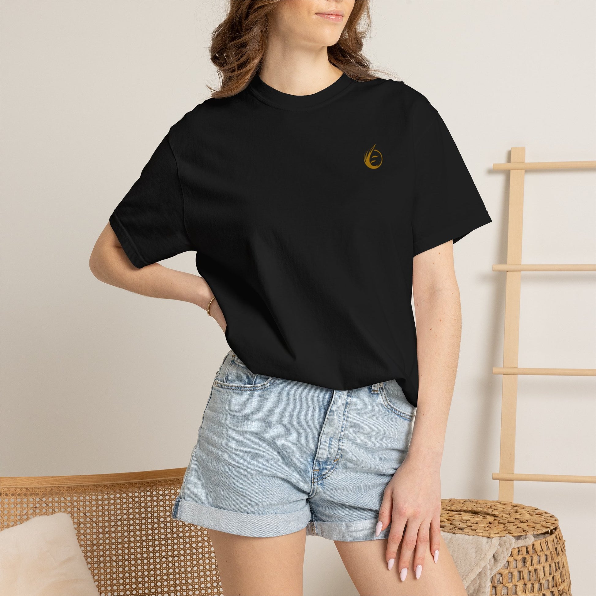Person wearing a black t-shirt with 'EssenceInnoCreate' printed on it and denim shorts.