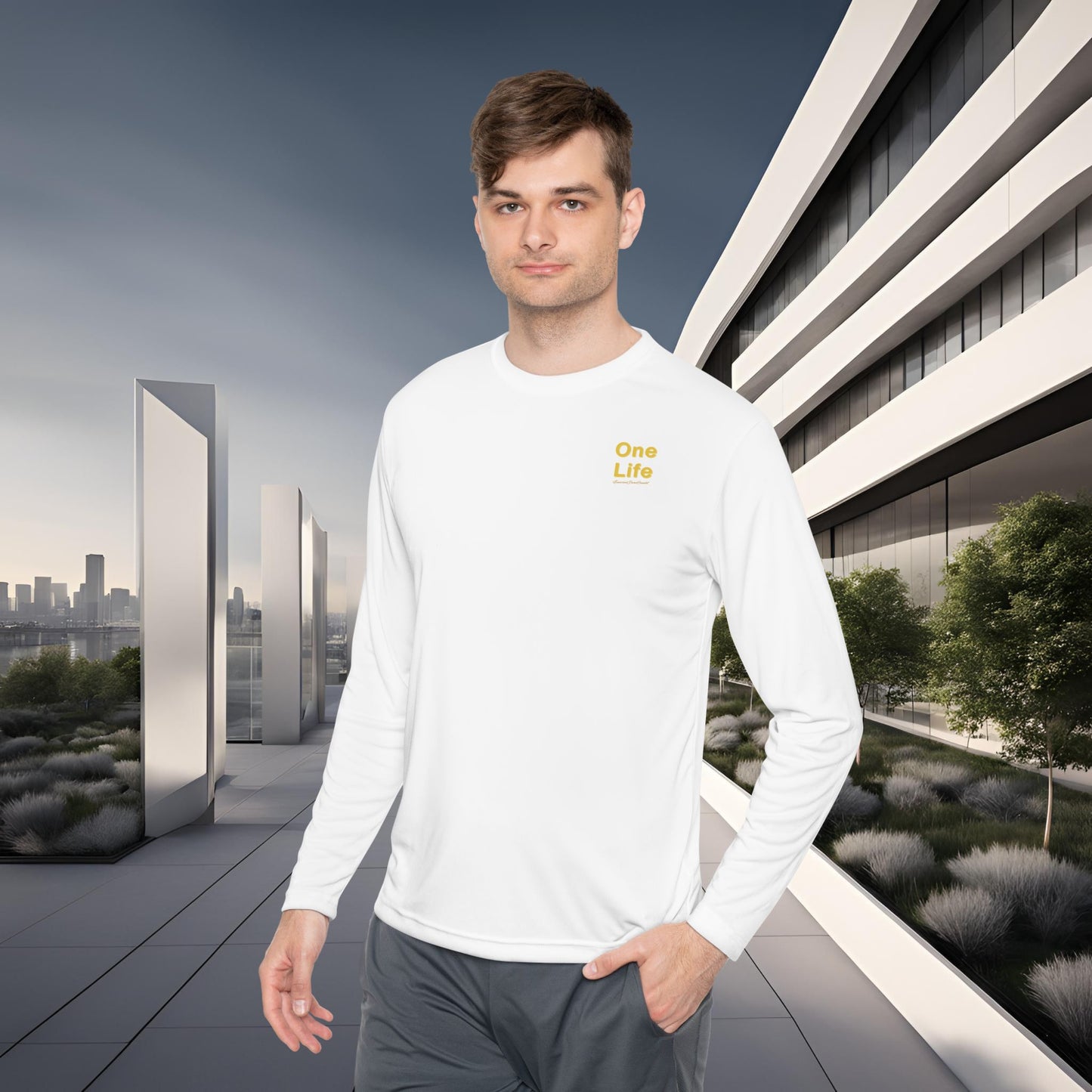 Man wearing a white long-sleeve shirt with 'One Life' text in a modern outdoor setting.