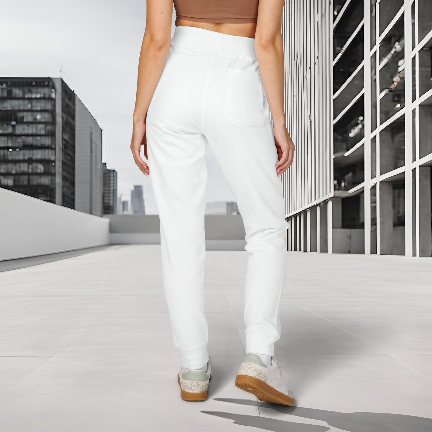 Person wearing white 'EssenceInnoCreate' Quiet Resolve pants walking on a rooftop with cityscape background