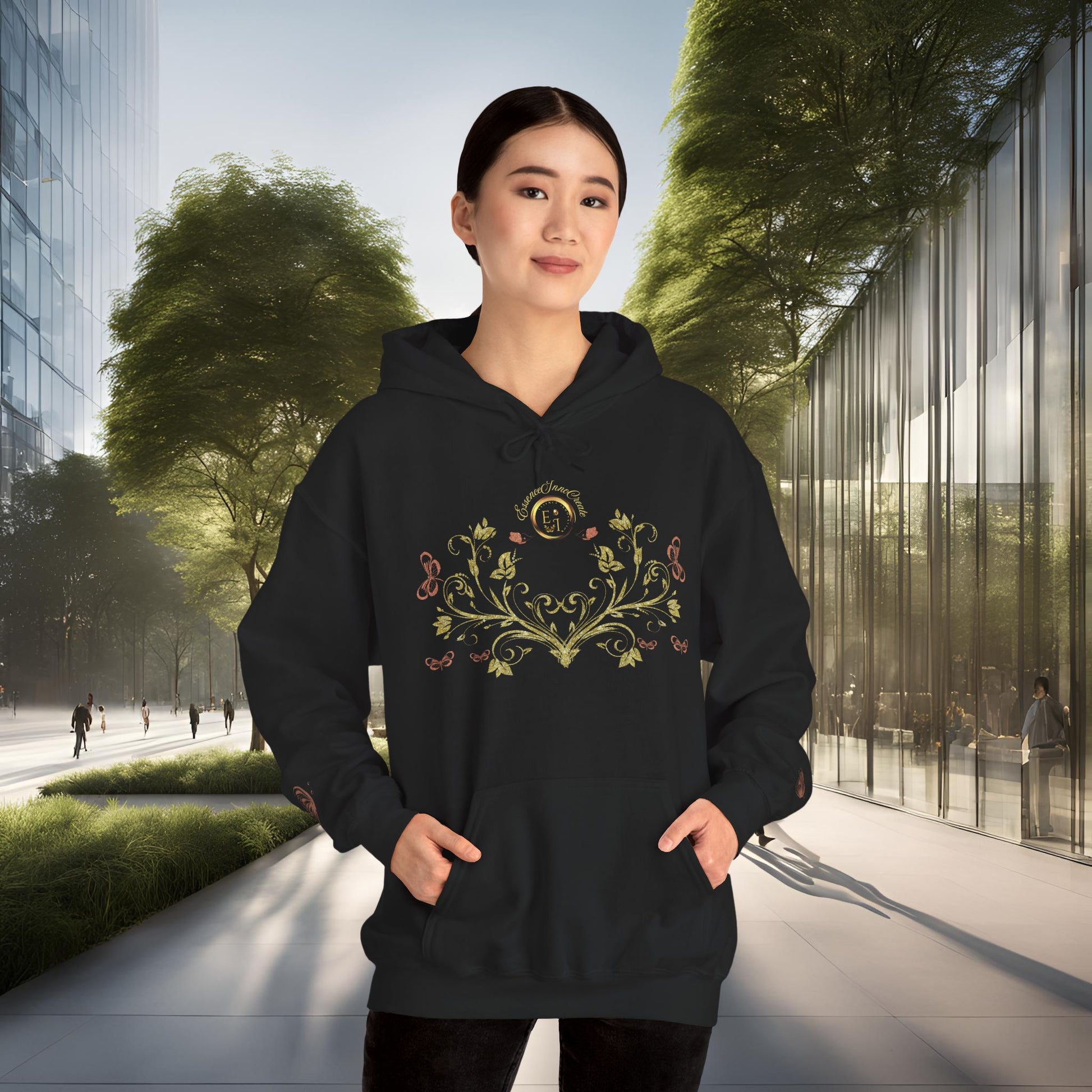 Person wearing a black hoodie with a decorative Essence Innovation Bohemian Butterfly Crest emblem in an urban setting