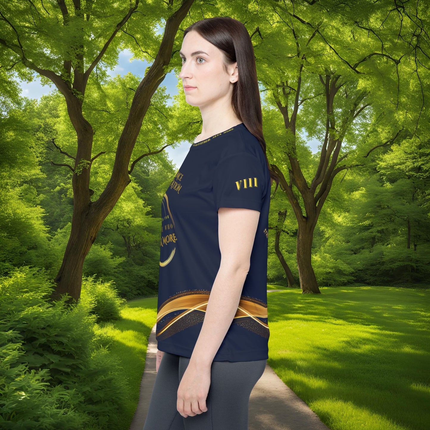 Woman wearing a navy blue t-shirt with gold design in a park setting