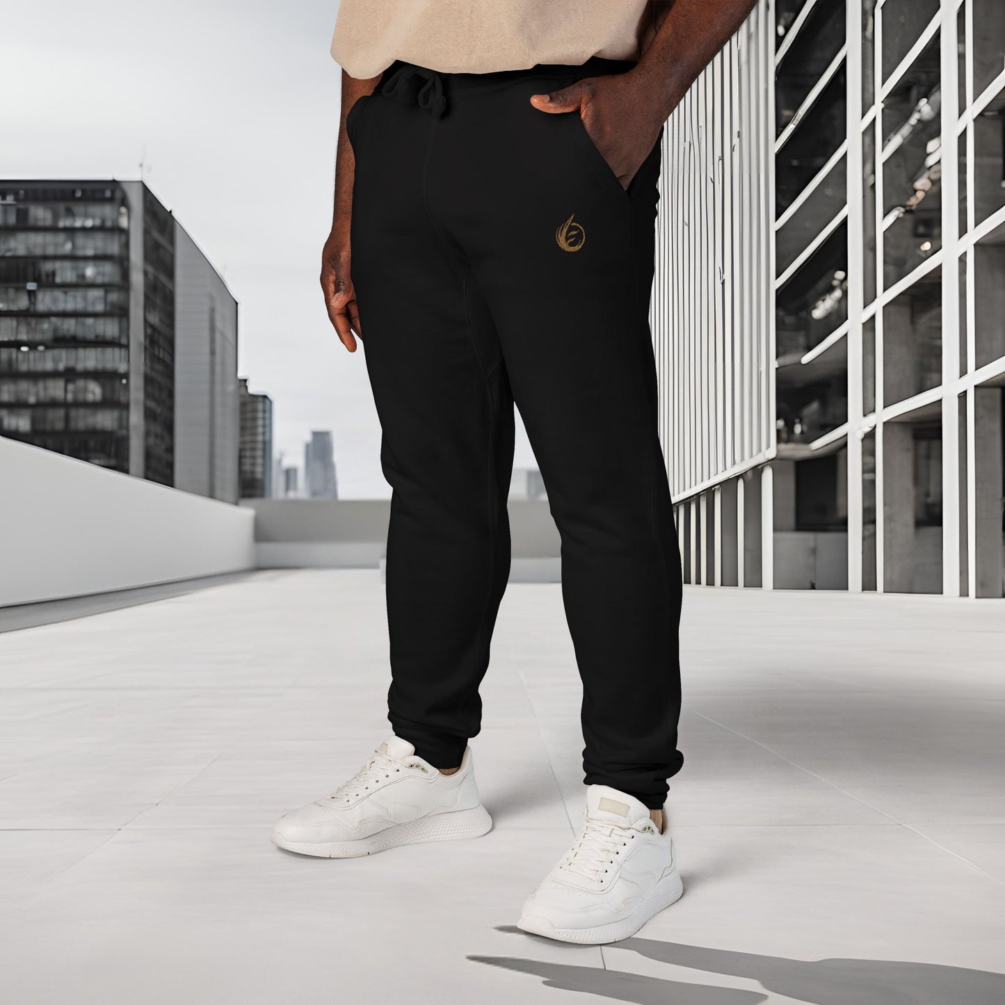 Person wearing black 'EssenceInnoCreate' Quiet Resolve jogger pants and white sneakers on a rooftop with cityscape background