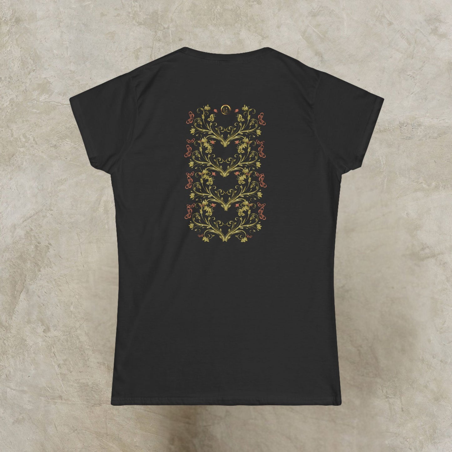 Black t-shirt with a floral Essence Innovation Bohemian Butterfly Crest design on the back against a beige background