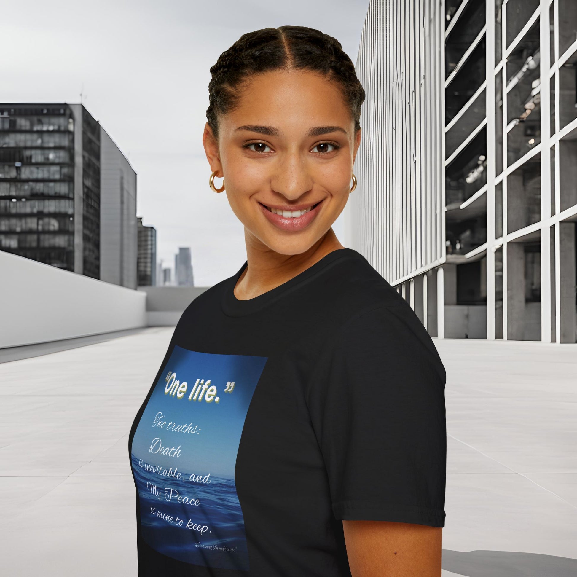 Person wearing a black 'One Life' t-shirt with a blue graphic and text, standing in an urban setting.