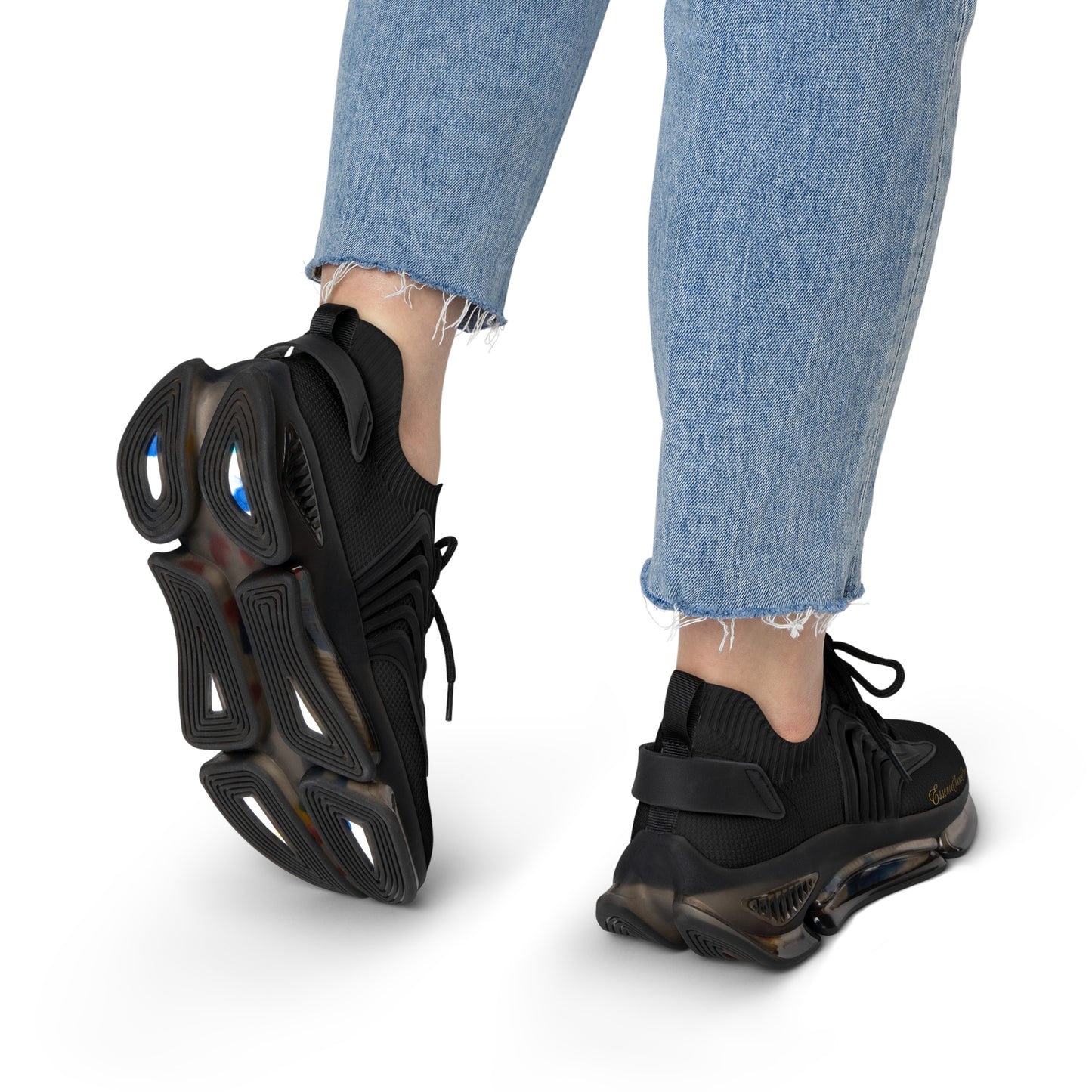Black 'EssenceInnoCreate' sneakers worn with light blue jeans on a white background