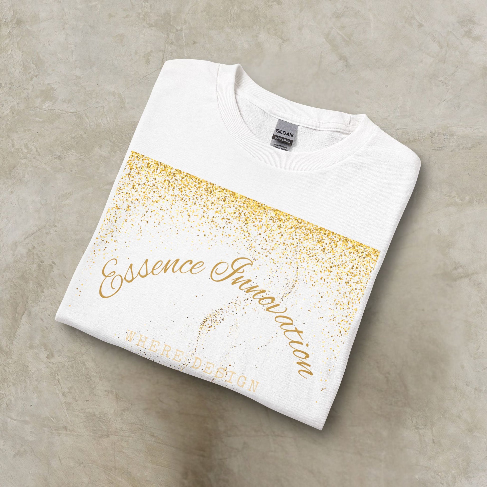 Folded white t-shirt with gold Essence Innovation 'Design Meets Soul' text on a gray surface