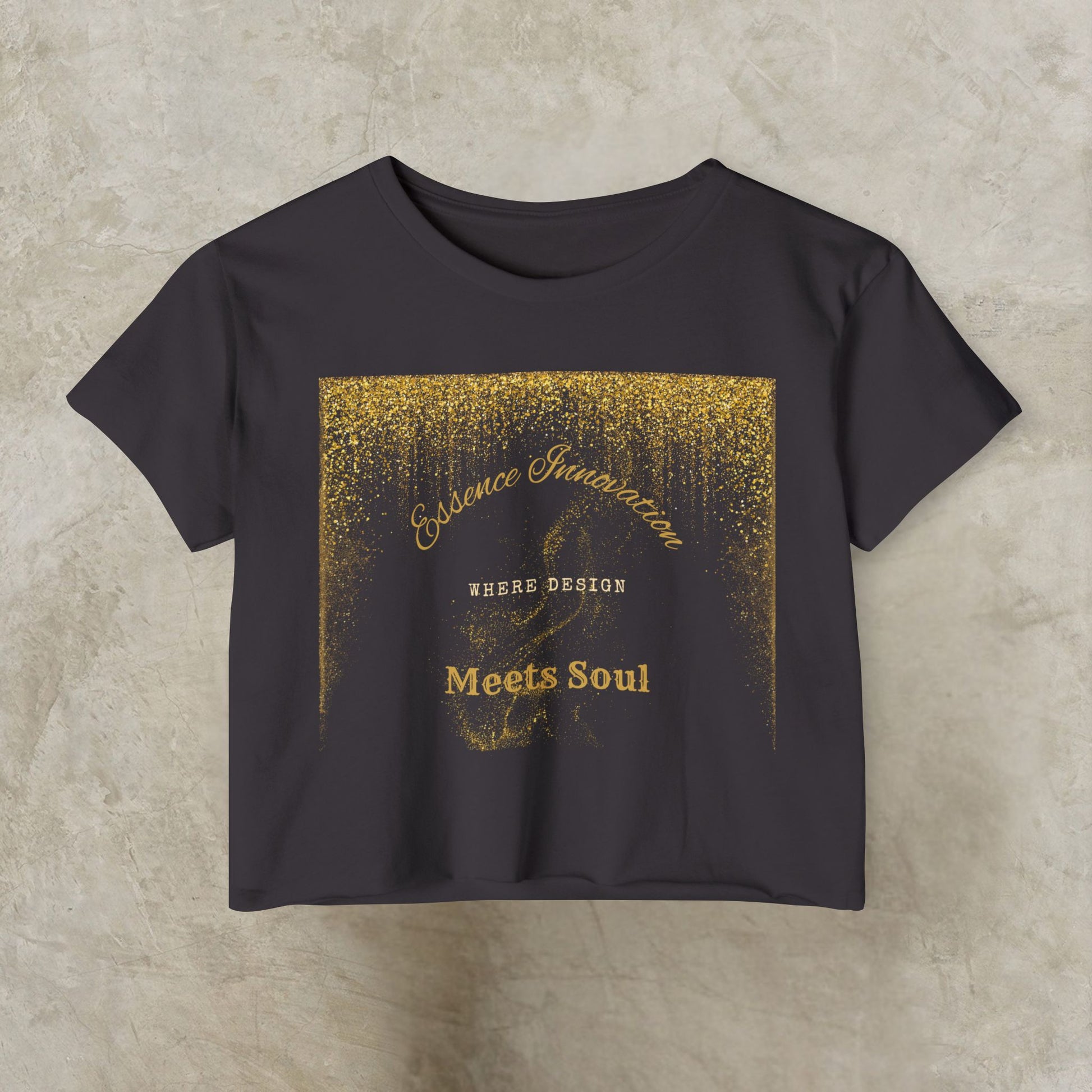 Black t-shirt with gold Essence Innovation 'Design Meets Soul' text and design on a beige background