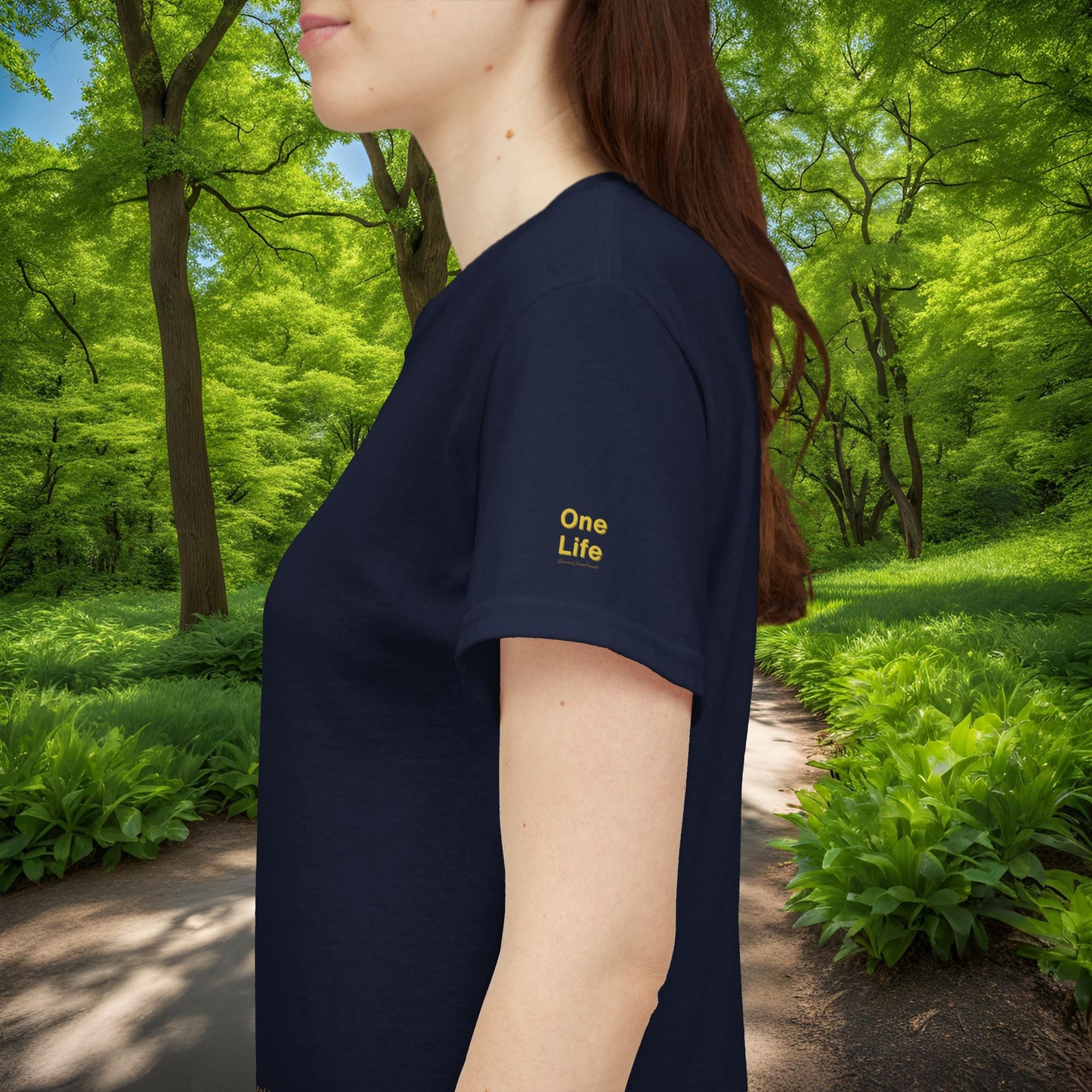 Person wearing a navy blue t-shirt with 'One Life' text in a forest setting