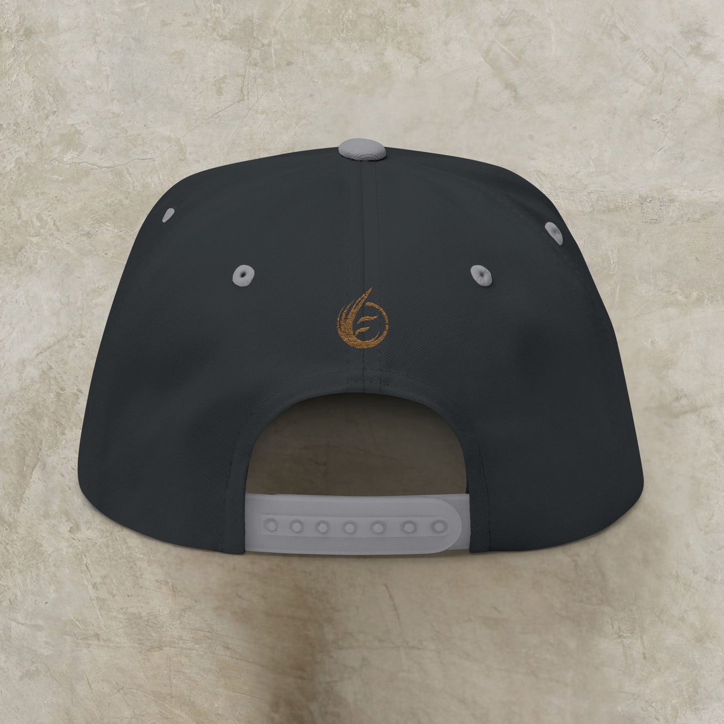 Black cap with a EssenceInnoCreate logo on the back against a beige background