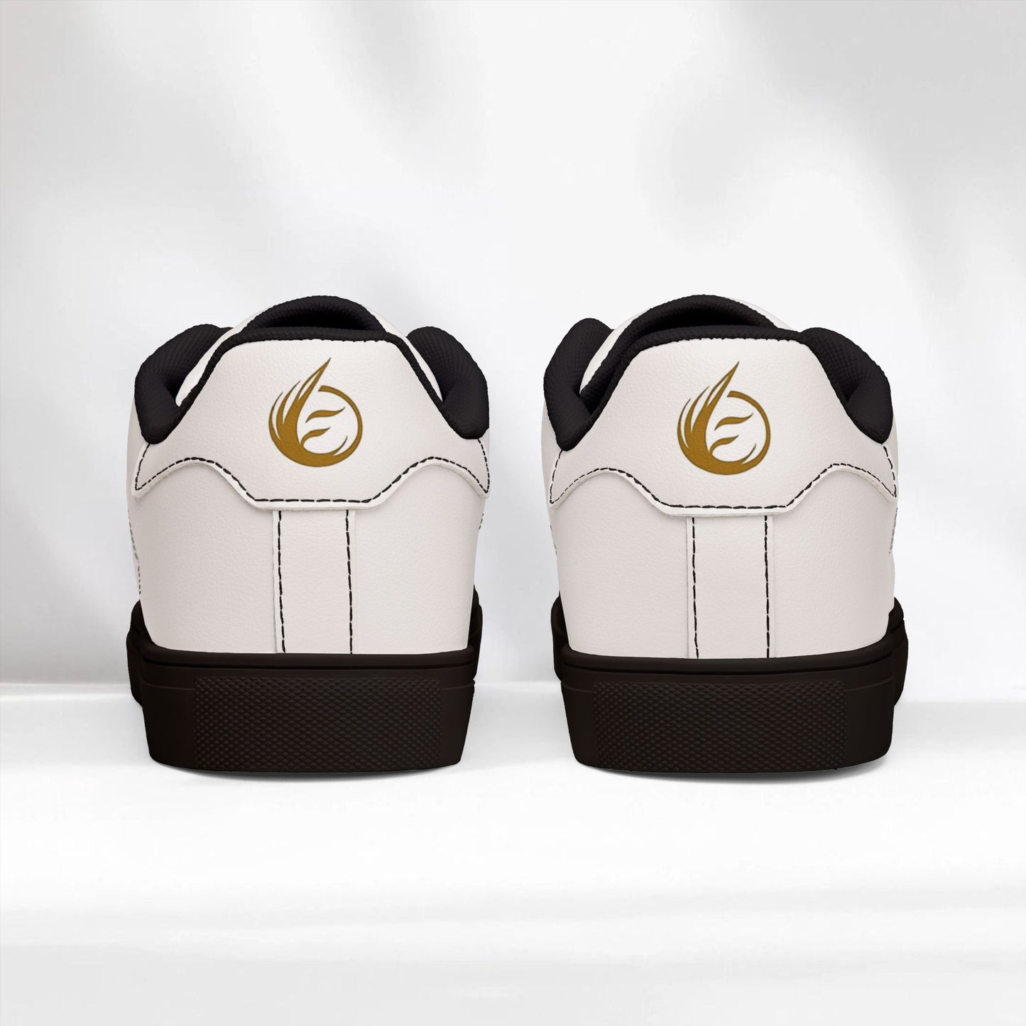 White EssenceInnoCreate sneakers with black soles and gold logo on a white background